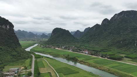 aerial drone shot of river passing through hills filled with greeneries