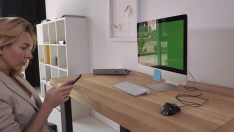 Adult woman using smartphone at work.