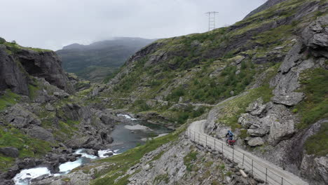 person cycling down a scenic part of the famous rallarvegen, the hiking and cycling road between the mountains in finse and the fjord in flåm, norway