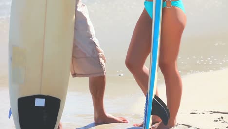 una pareja con tablas de surf en una playa