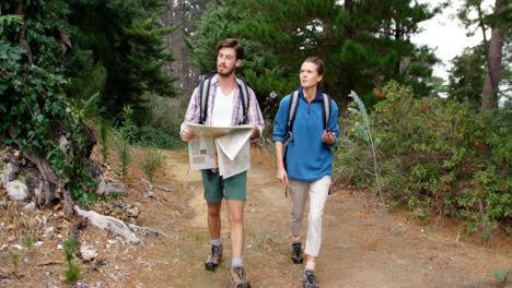 Un-Par-De-Excursionistas-Mirando-Un-Mapa-Y-Una-Brújula.