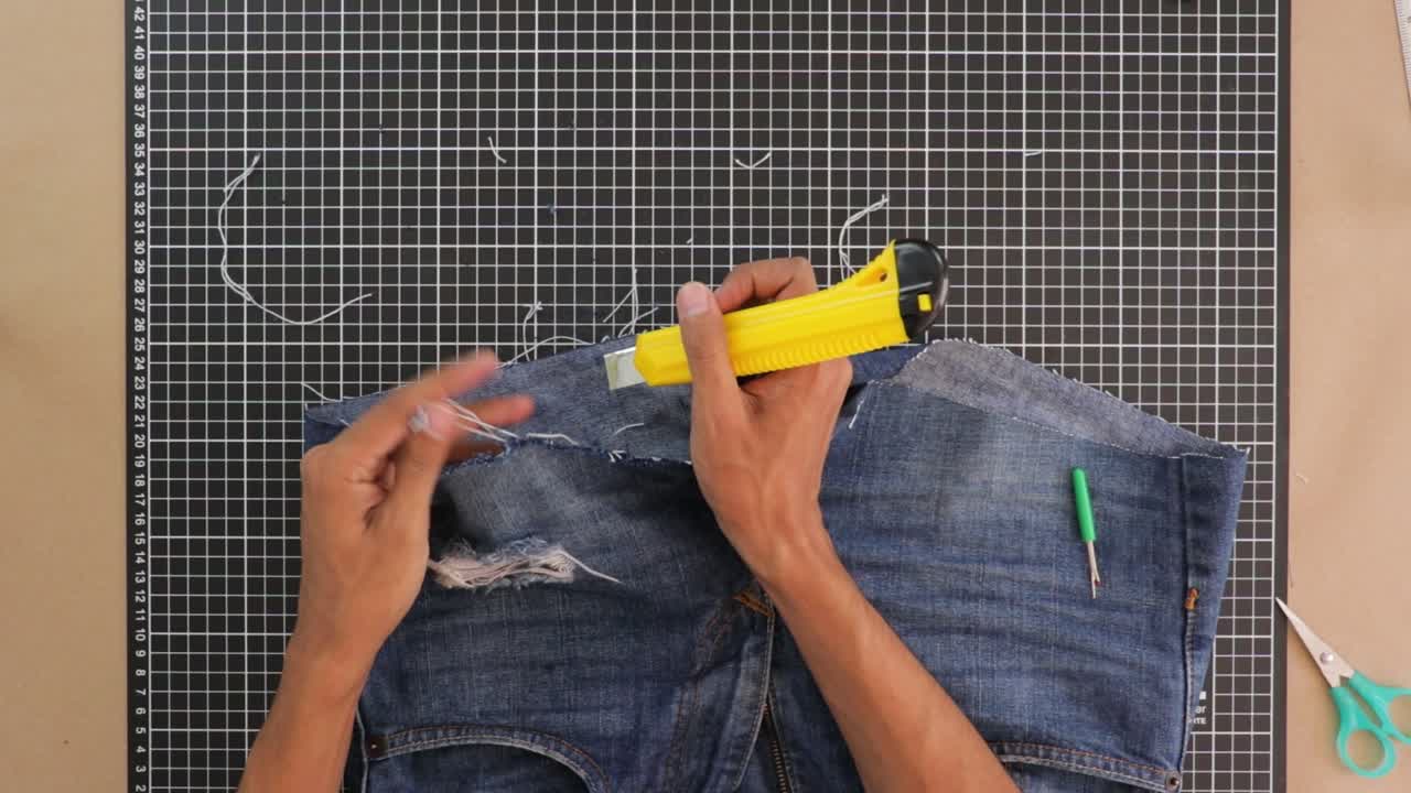 Person cutting with cutter and reshaping shorts