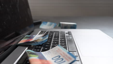 vista lateral de una computadora portátil con billetes de banco en el teclado, el negocio en línea trae efectivo
