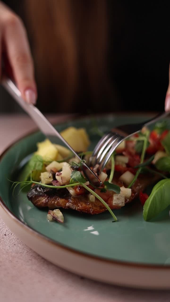 mujer comiendo pescado a la parrilla con ensalada
