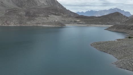 Video-Cinematográfico-Areial-Del-Lago-Sadpara-Con-Montañas-Rocosas,-Agua-Clara-Y-Hermoso-Cielo-Azul-En-Sakardu,-Pakistán