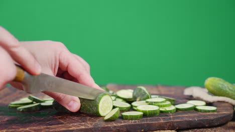 Men hands cut cucumber into slices on a wooden cutting Board.