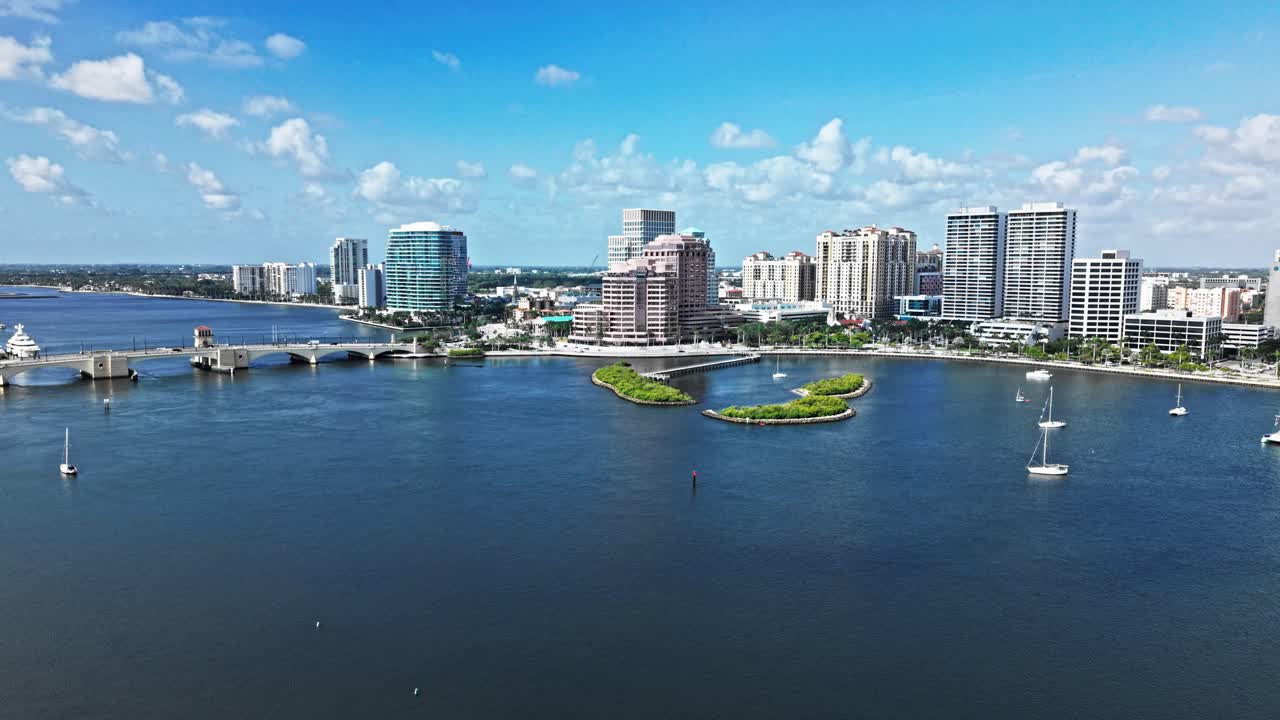 Push in drone shot of One Flagler, Phillips Point Building and West Palm Beach cityscape during the day in Florida, USA