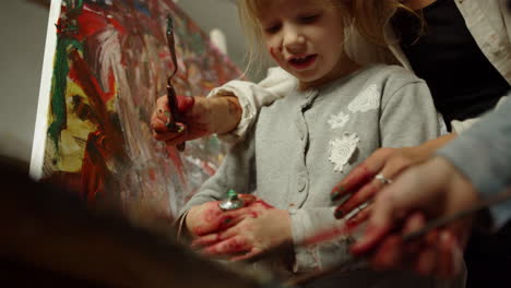 mujer desconocida pasando tiempo en el estudio de arte. chica enfocada apretando pintura en el interior.