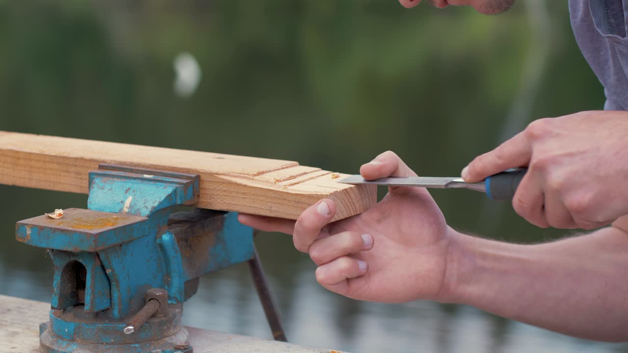 Carpenter removes wood using a chisel