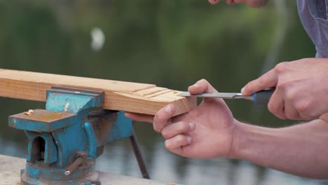 carpenter removes wood using a chisel