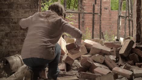 mujer moviendo escombros y escombros después del desastre