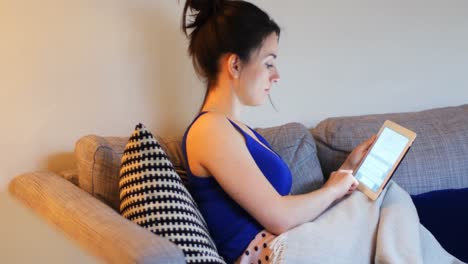 mujer usando tableta digital en el sofá en la sala de estar 4k