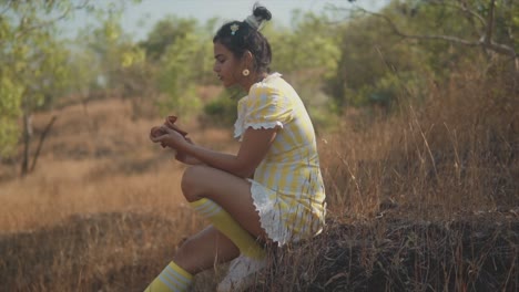 dreamy young beautiful indian woman tenderly inspects a traditional red clay pot in her hands
