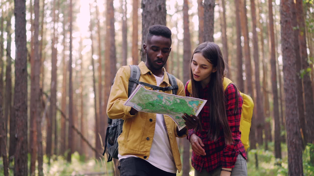 Couple Hiking and Using a Map in a Forest