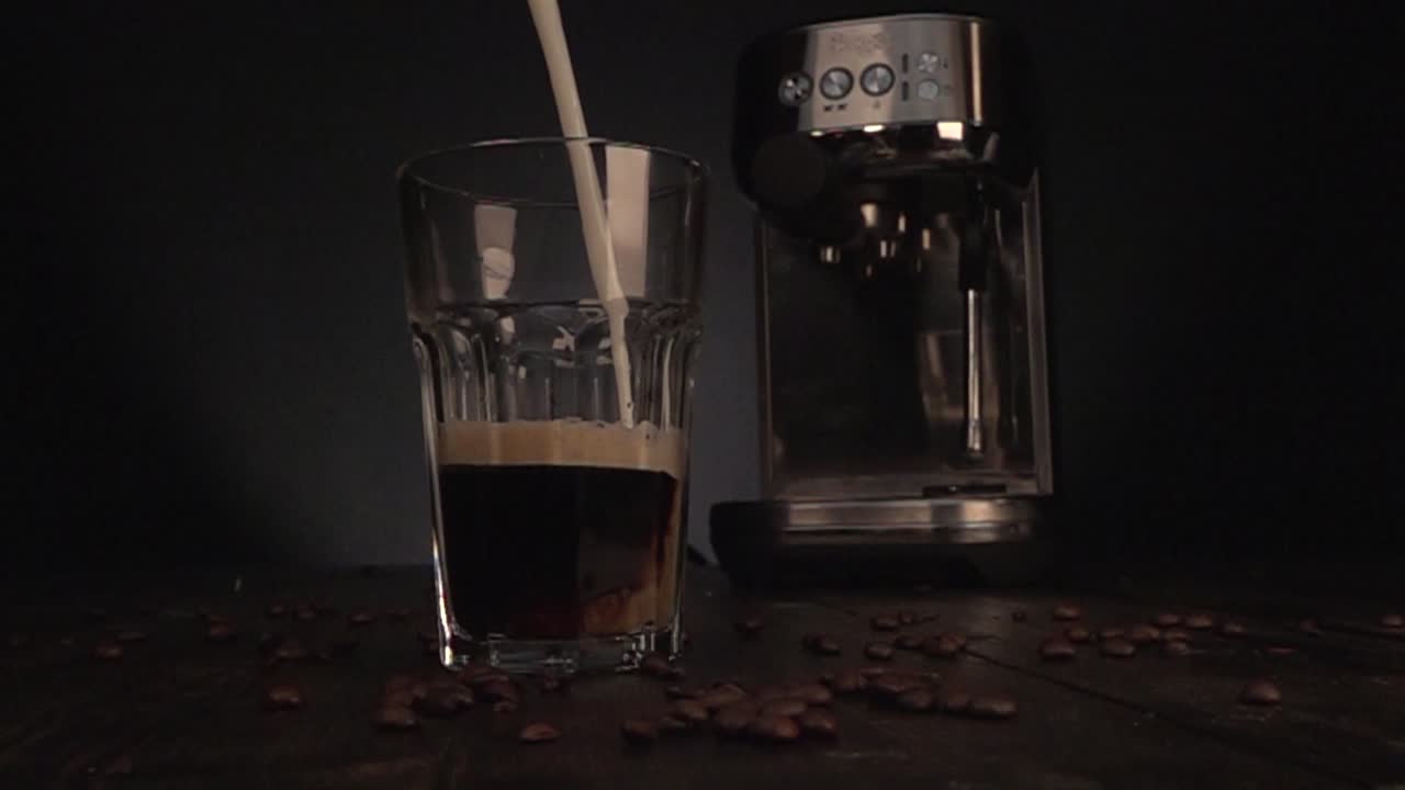 Milk being poured in coffee glas in slow motion