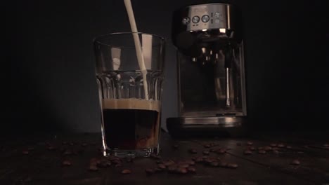 milk being poured in coffee glas in slow motion