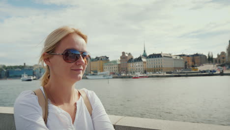 a woman in sunglasses is resting on the stockholm embankment holiday in europe concept 4k video