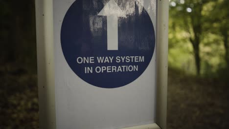 one way system in operation sign with upward arrow at the kennall vale nature reserve in england