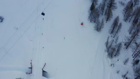 Aerial-of-busy-skiresort,-revealing-the-beautiful-snow-covered-town-of-Saas-Fee-in-Switzerland