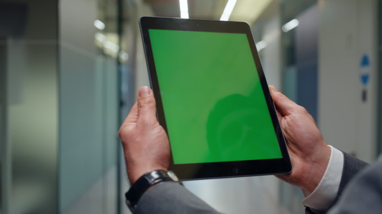 Hands holding greenscreen tablet reading work tasks on go closeup. Man using pad