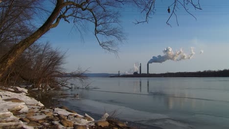 Rauch-Steigt-Aus-Einem-Entfernten-Kraftwerk-Entlang-Eines-Flusses-2