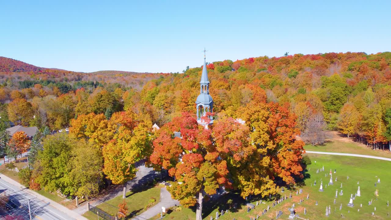 Aerial drone shot of typical canadian church and cemetary with autumn colors in Estrie region, Quebec, Canada
