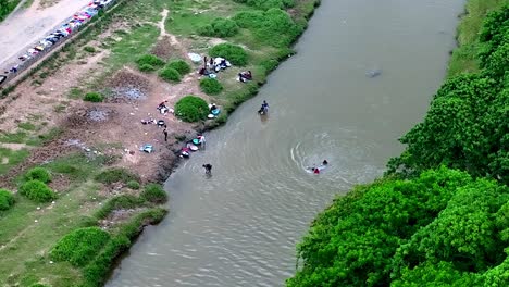 los niños se bañan en las aguas del río masacre mientras las mujeres lavan la ropa