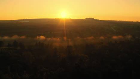 Disparo-Aéreo-De-Un-Dron-Volando-Hacia-Atrás-Revelando-Un-Brumoso-Amanecer-Impresionante