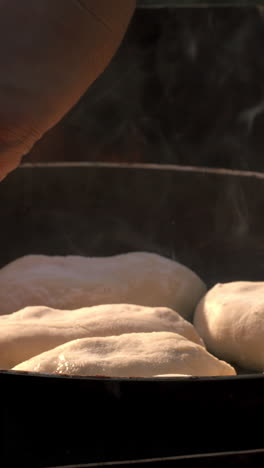 cooking bread in a pan over an open flame