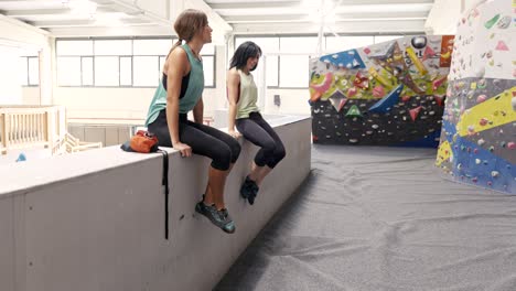 unrecognizable women standing near climbing wall in gym