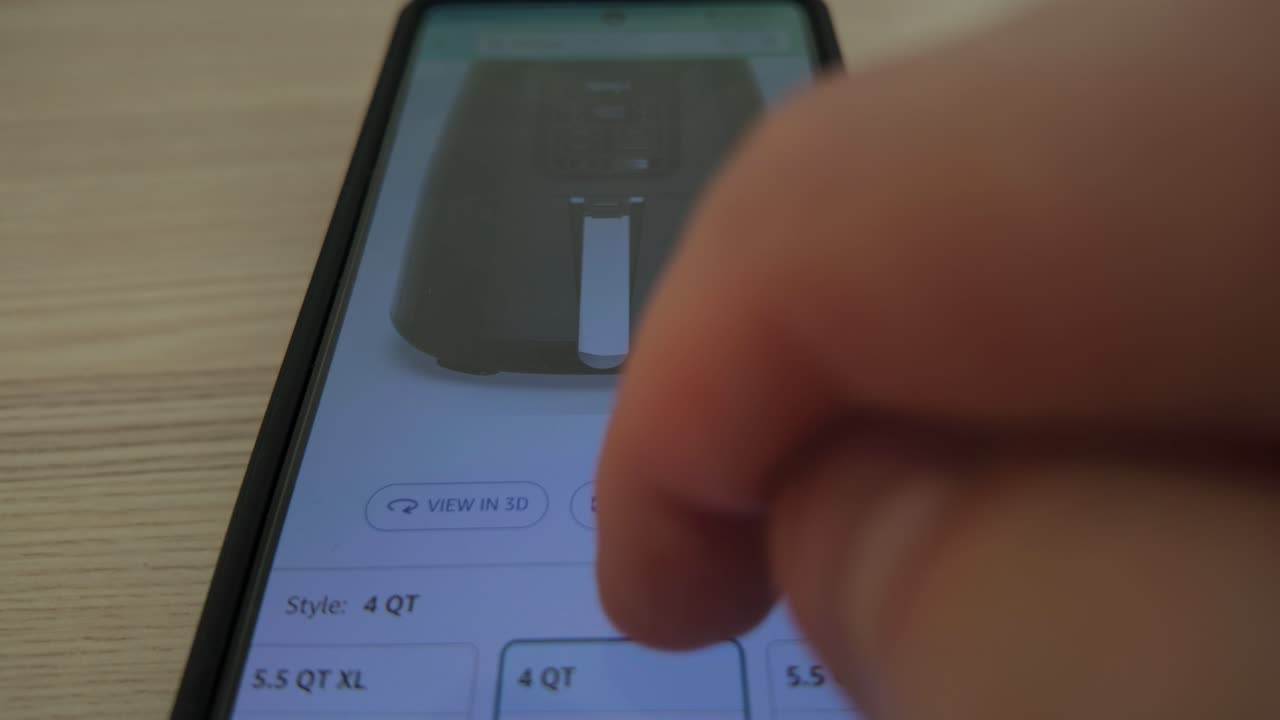 Finger scrolling through Amazon shopping app on smartphone to browse deals and product options