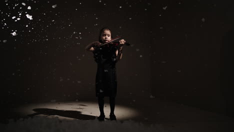 young girl playing violin in a winter wonderland