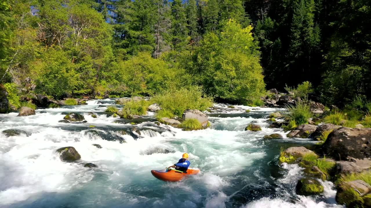 Vista aerea di un uomo in kayak da acque bianche nella sezione Mill Creek sul tratto superiore del fiume Rogue nell'Oregon meridionale.