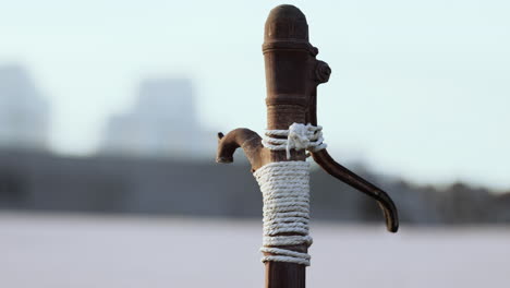 Rusty-old-metal-water-pump-on-sand-beach