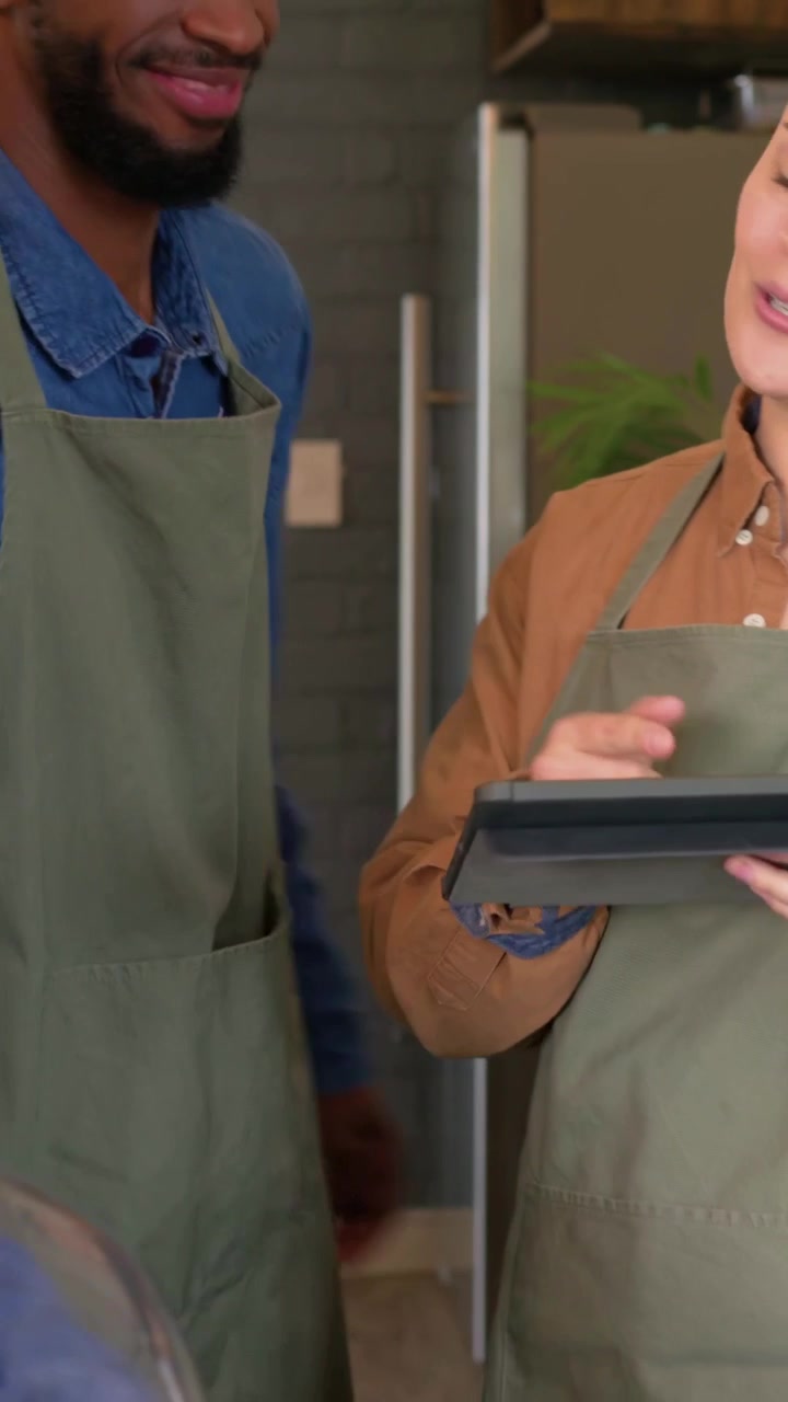 Video verticale: Appare il telefono del cliente, barista con grembiule che tiene un tablet e accetta il pagamento al bar