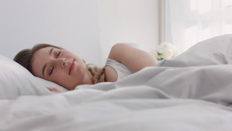 beautiful caucasian woman waking up in bed after restful sleep smiling happy ready for new day