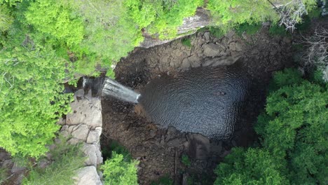 top down aerial view, water falling from cliff in natural pool