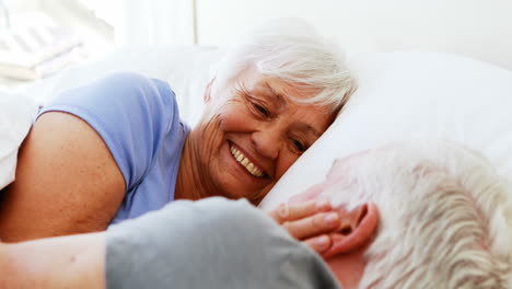 Feliz-Pareja-De-Ancianos-Interactuando-Entre-Sí-Mientras-Están-Acostados-En-La-Cama