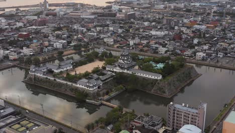 Aerial-view-of-Imabari-Ocean-Castle-and-City-at-Sunrise,-Ehime-Japan