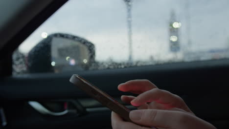 woman using smartphone in car during rain