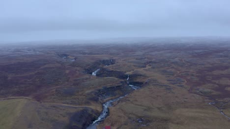 aerial backwards shot of deep selá river floating in hrútafjörður bay north iceland during mystical foggy day