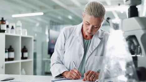 scientist in laboratory taking notes