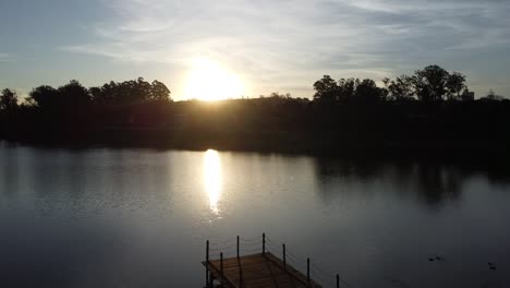 Rückwärtsbewegung-Mit-Drohne,-Die-Den-Wunderschönen-Sonnenuntergang-Und-Die-Spiegelung-Im-Wasser-Filmt