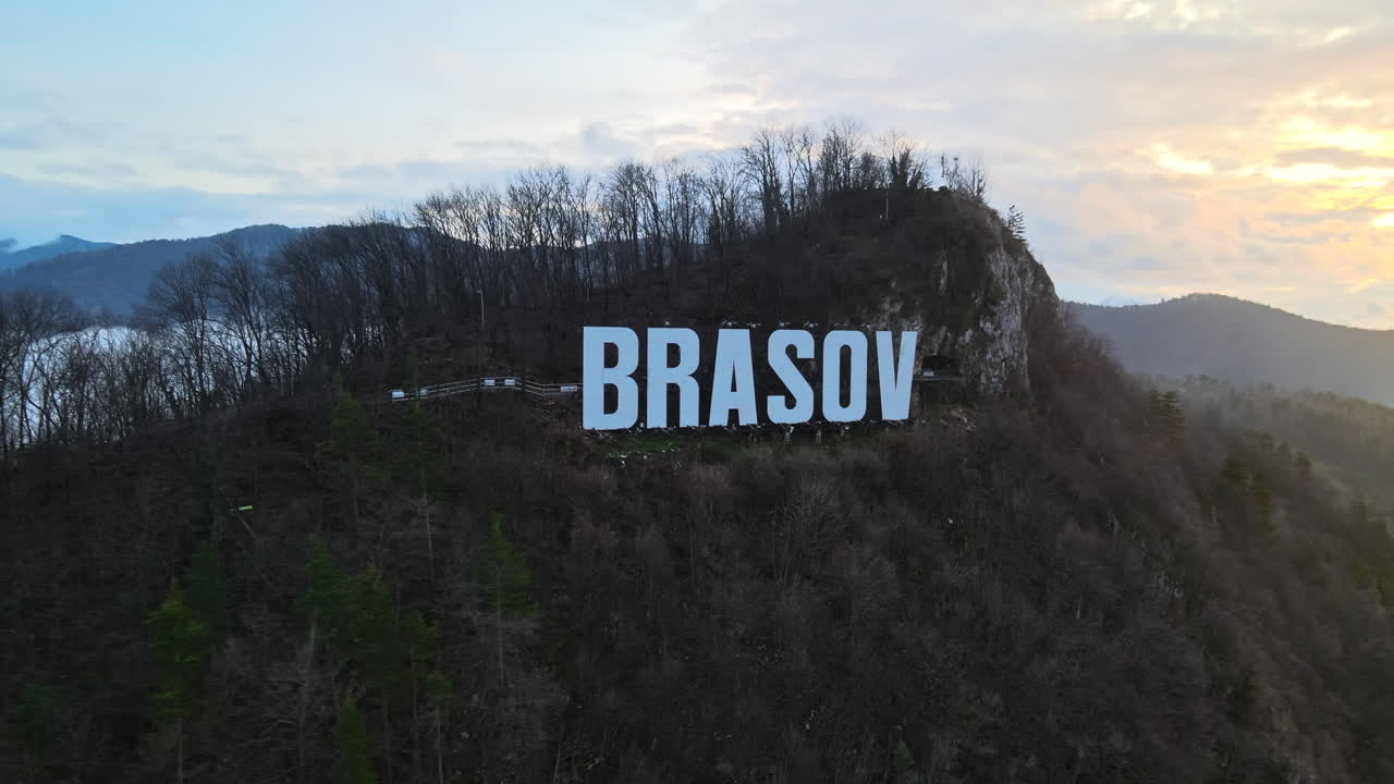 Brasov sign on the top of the hill near the city, bare trees, low clouds, Romania