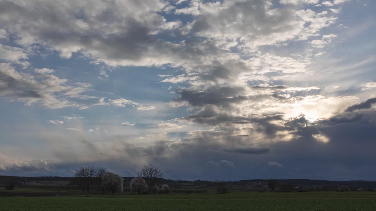 lapso de tiempo de nubes rápidas con rayos de sol ligeros y nubes de lluvia con puesta de sol