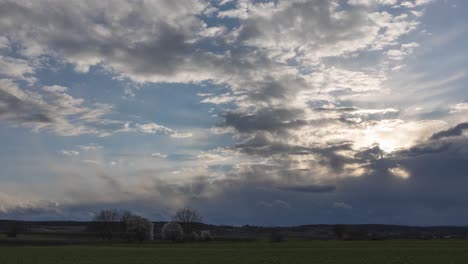 Zeitraffer-Von-Schnellen-Wolken-Mit-Leichten-Sonnenstrahlen-Und-Regenwolken-Mit-Sonnenuntergang