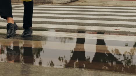 Business man tourist person with umbrella and raincoat on rainy european city street, lights reflecting, walking in Barcelona or Amsterdam during the rain