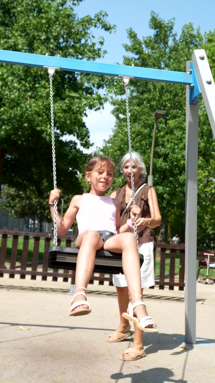 Nonna che Spinge la Nipote sull'Altalena al Parco