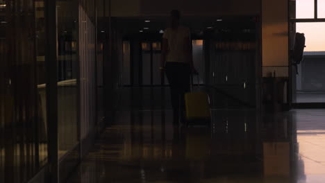 mujer con maleta rodante caminando en el aeropuerto