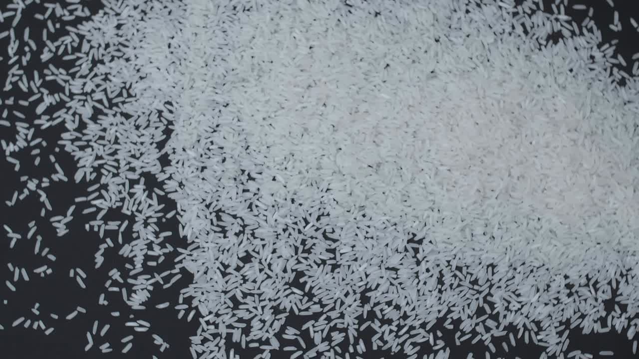 Rice Falls On  Over A Black Background And Spills Around Slow Motion Close Up